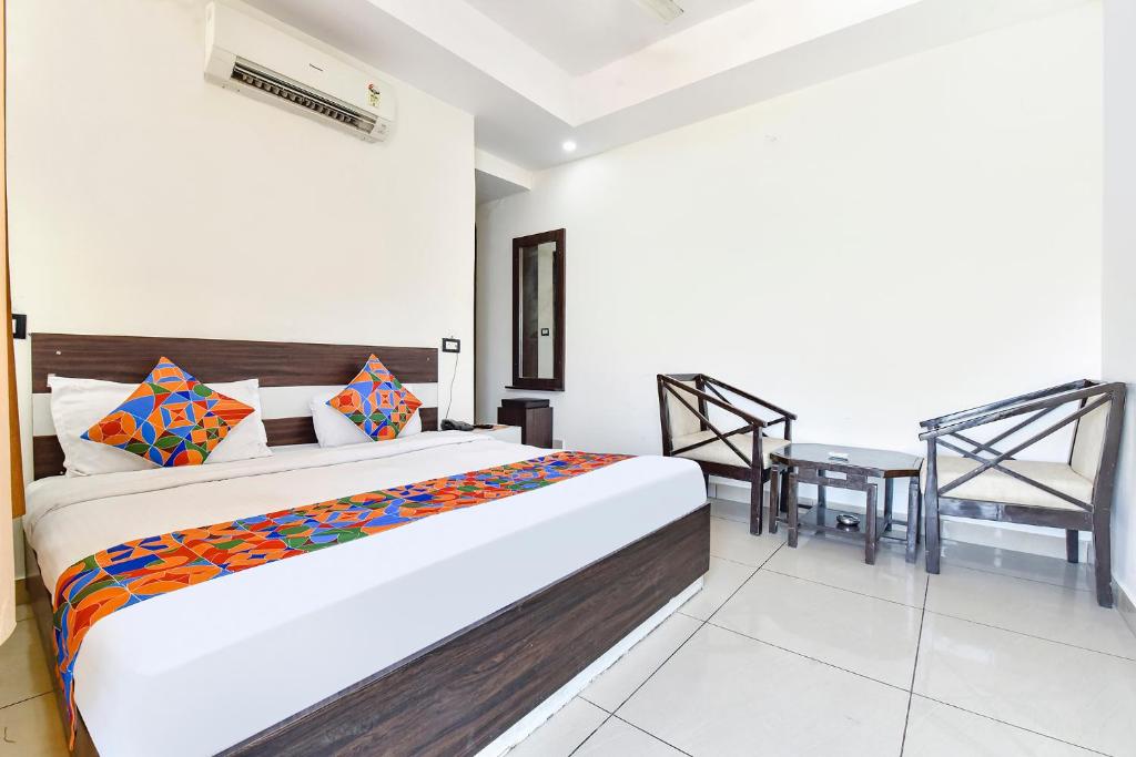 a bedroom with a large bed and a table at FabHotel KRB Paradise in Dehradun