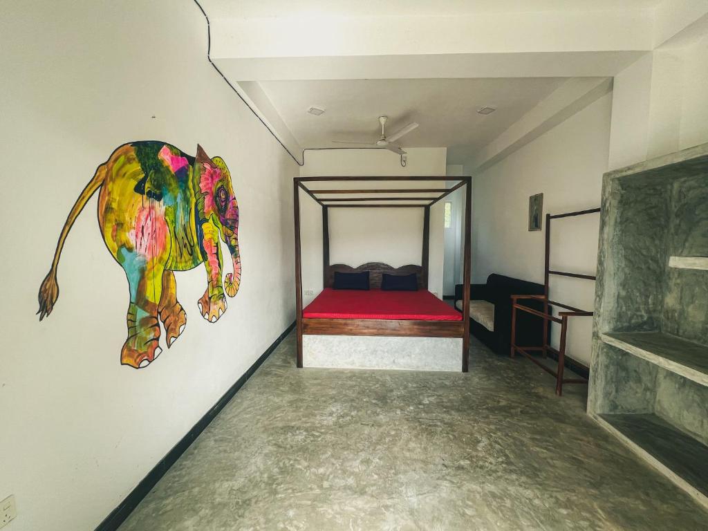 a room with a bed and a painting of an elephant on the wall at Leyon Paradise Hotel in Unawatuna