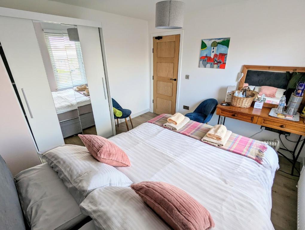 una camera da letto con un grande letto con cuscini sopra di Cosy guest room in a family home a Edimburgo