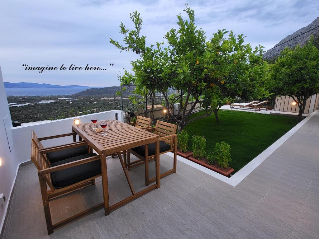 a wooden table and chairs on a patio with a view at Saint George House in Ierapetra