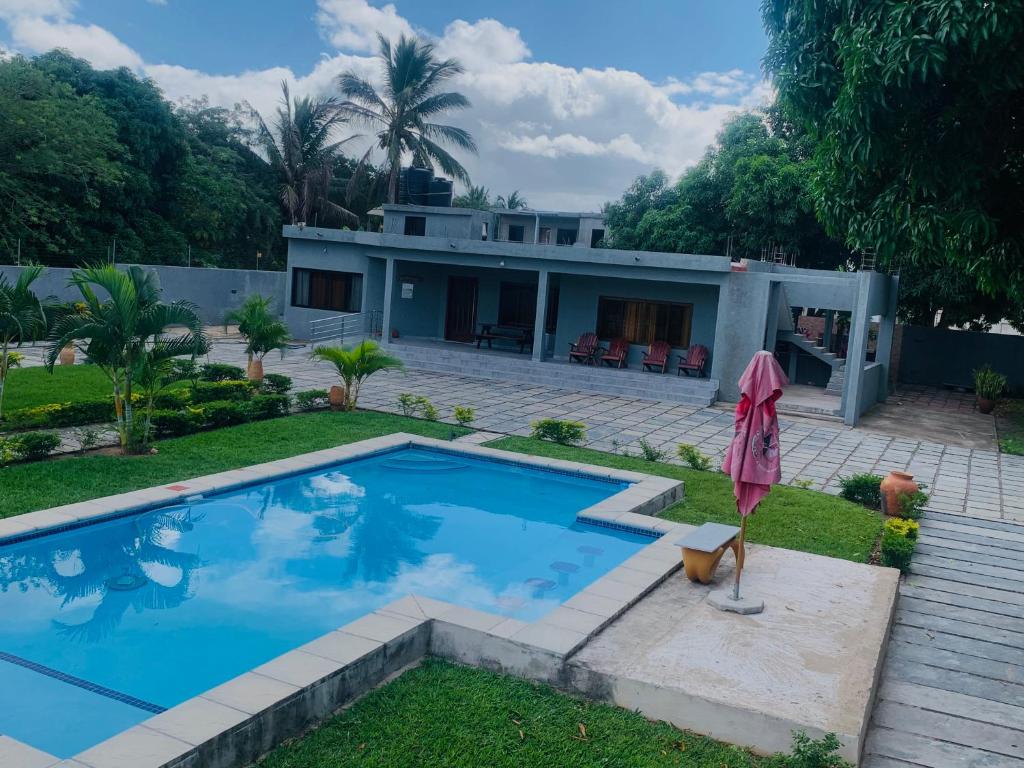 a house with a swimming pool in front of it at House of joy Bilene in Vila Praia Do Bilene
