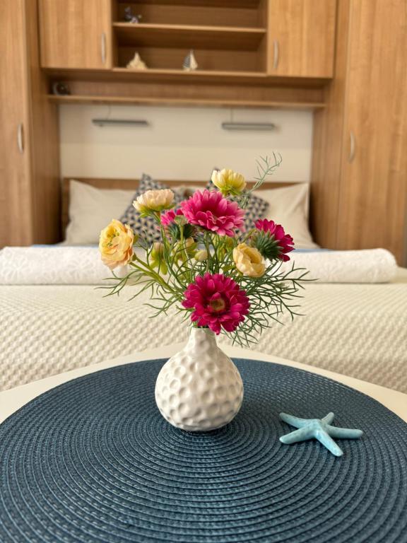 a vase with flowers in it on a table at Guesthouse MM in Dubrovnik