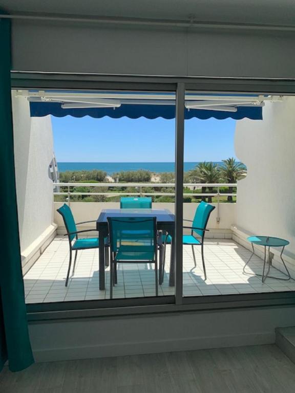 un patio avec une table et des chaises sur une terrasse dans l'établissement Vittoria Immobilier-375-Vue mer- REGLEMENT SUR PLACE -Chèques Vacances acceptés, à La Grande Motte