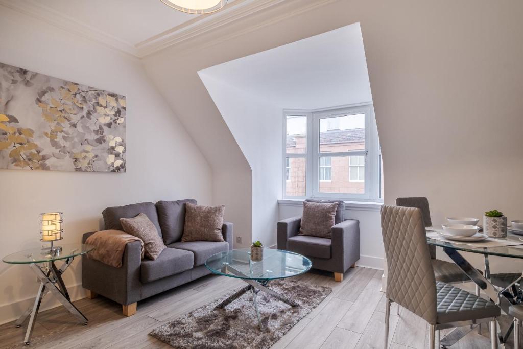 uma sala de estar com um sofá e duas cadeiras e uma mesa em Peterhead Stay - SJA Stays - Modern 2 Bed Apartment em Peterhead