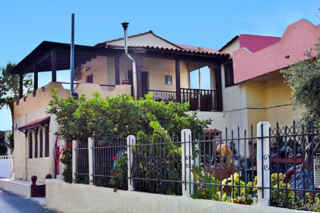 uma casa com uma cerca em frente em Gorgona Apt em Heraclião