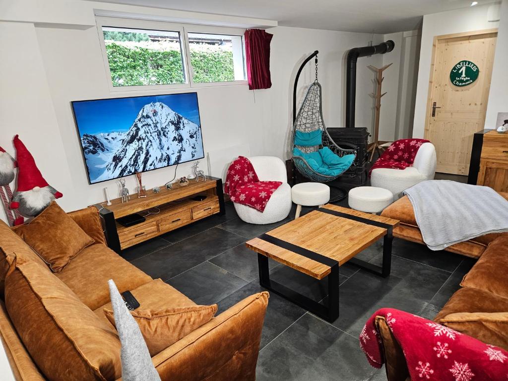 Il comprend un salon avec des canapés et une télévision à écran plat. dans l'établissement Les Fées Mer : appart 150 m² hypercentre calme 10p, à Chamonix-Mont-Blanc