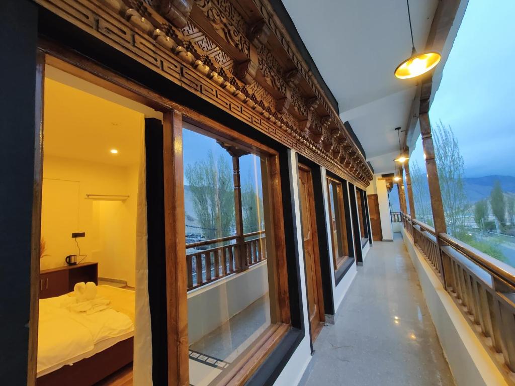 Zimmer mit Fenstern und einem Bett auf einem Balkon in der Unterkunft Zanu Residency in Leh