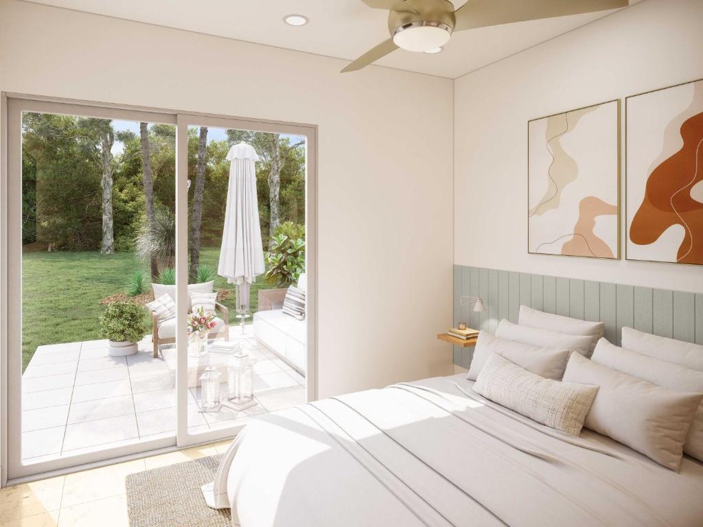 a bedroom with a white bed and a patio at The Health Lodge in Byron Bay