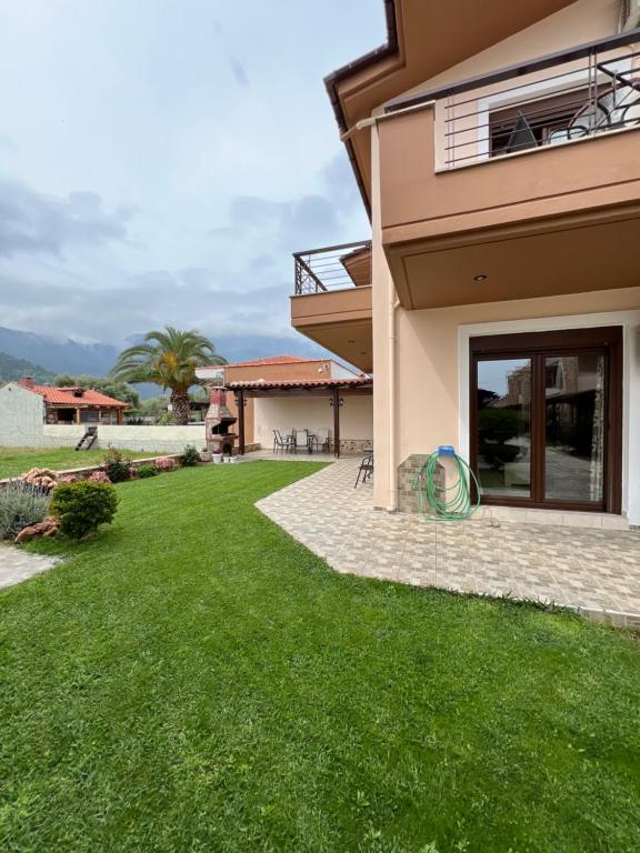a house with a green lawn in front of it at Penelope's Maisonette in Skala Potamias