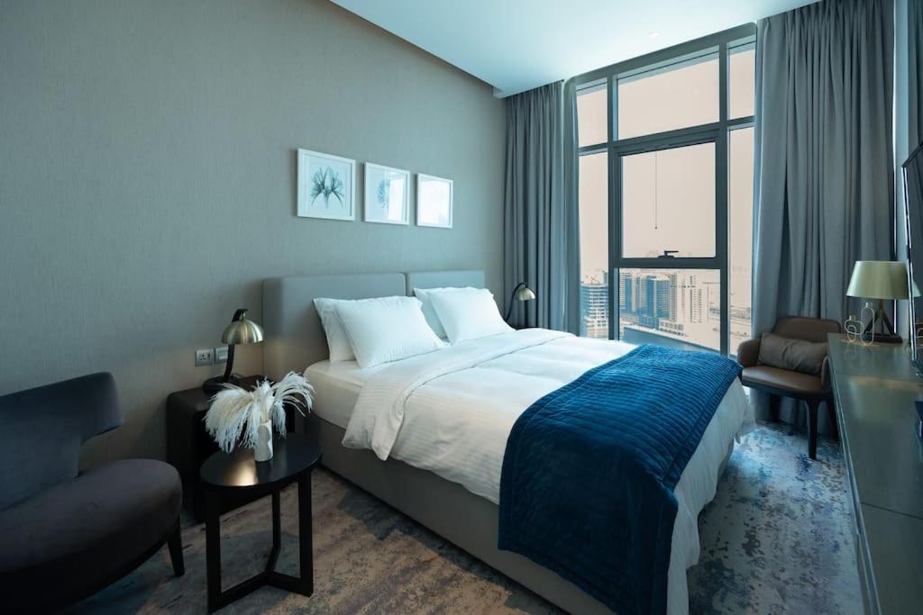 sypialnia z dużym łóżkiem i dużym oknem w obiekcie Business Bay centrally located Cozy Studio w Dubaju
