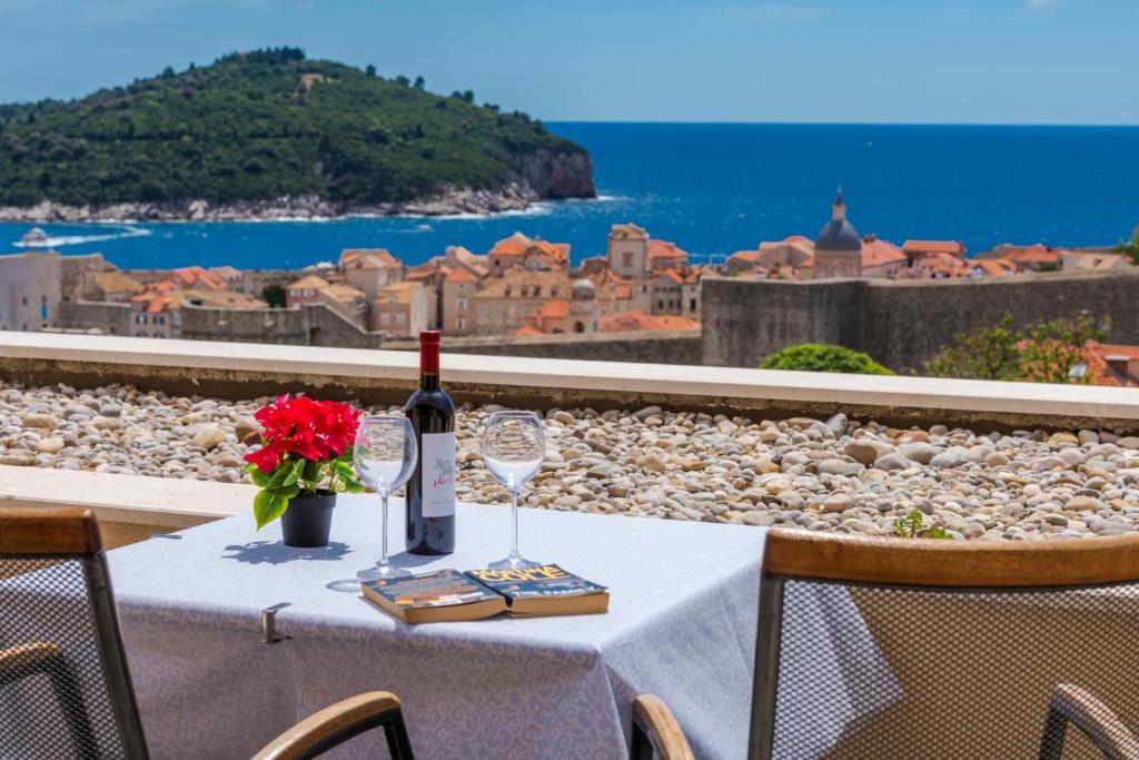 una mesa con una botella de vino y una copa en Apartment Viki, en Dubrovnik