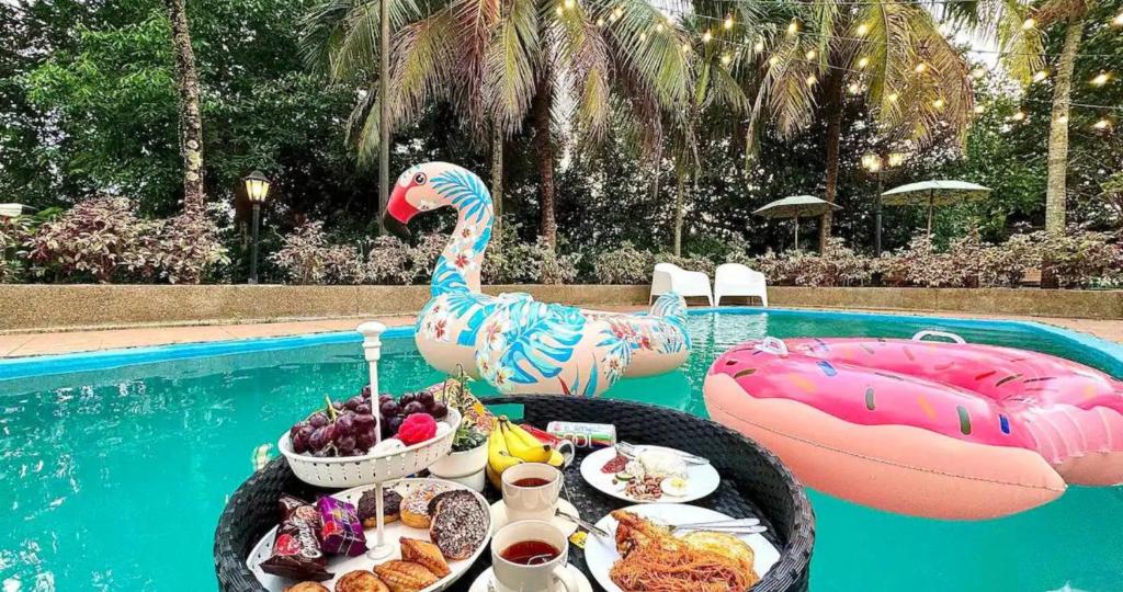 A'Famosa Bungalow*Private Garden Stage*22Pax*NEW في Kampong Ulu Pegoh: مسبح مع طاولة طعام ومسبح قابل للنفخ