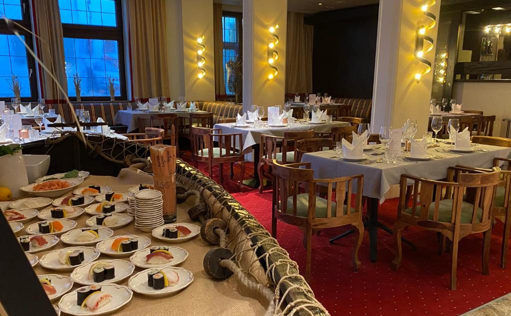 a restaurant with tables with plates of food on them at Sporthotel Igls in Innsbruck