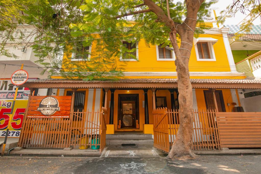 ポンディシェリにあるParambara Heritageの木の前の黄色い家