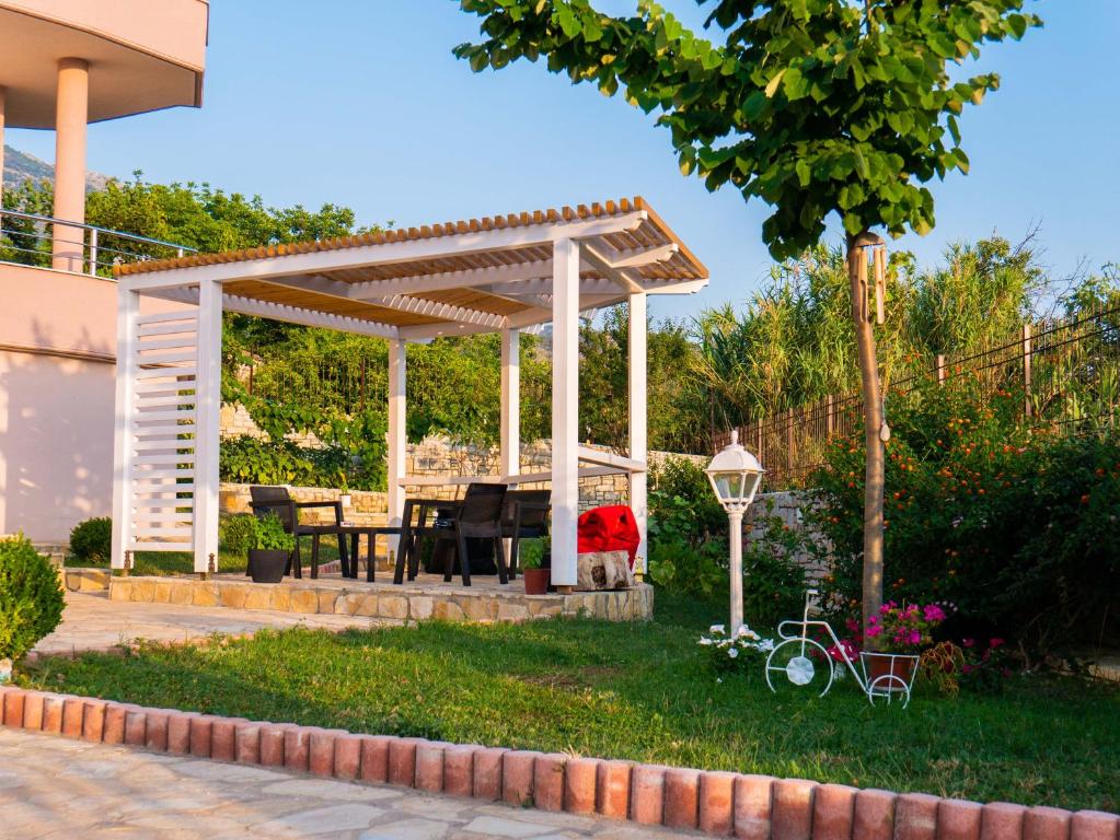 a wooden pergola with a table and a bike in a yard at Luxurious Attic Apartment in Tragjas