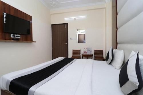 1 dormitorio con 1 cama grande y TV en la pared en Hotel Airport land, en Nueva Delhi