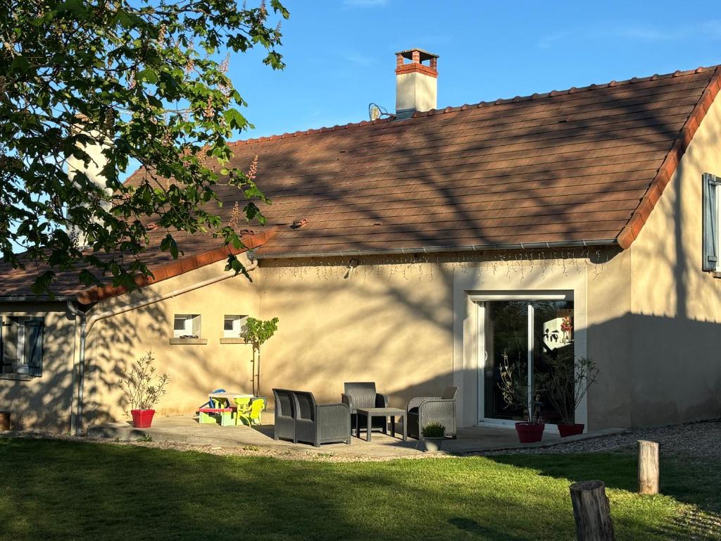 una casa con due sedie e un patio di Maison avec jardin clos, à quelques pas de la forêt de Tronçais a Saint-Bonnet-Tronçais