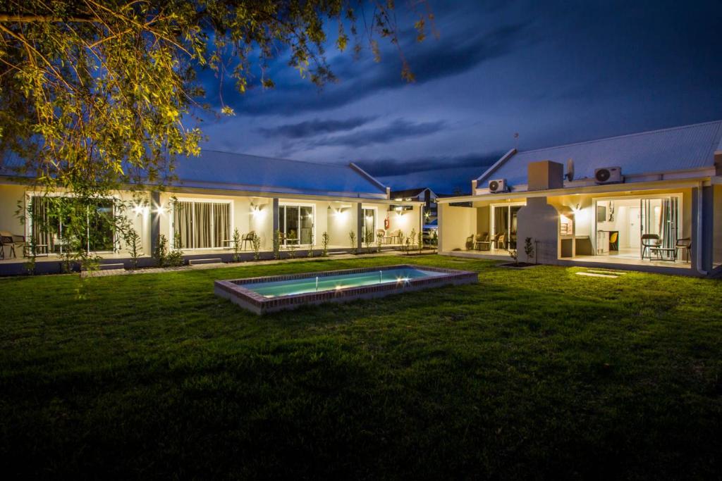 a house with a pool in the yard at night at El Dorado Hotel and Self Catering in Oudtshoorn