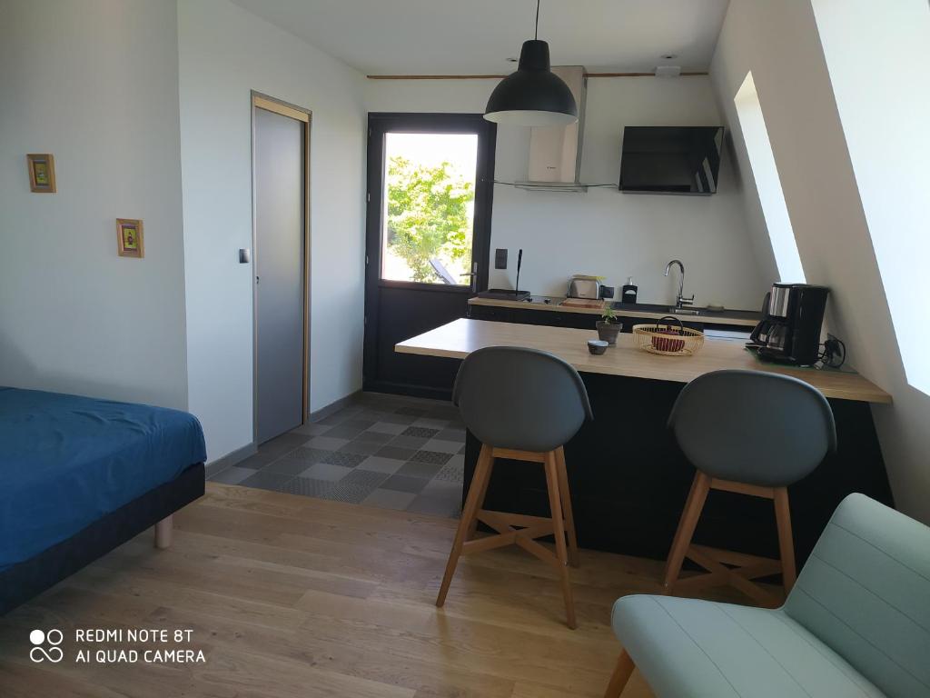 - une cuisine avec un comptoir et 2 chaises dans une pièce dans l'établissement Gîte de la chabanne, à Lentillères