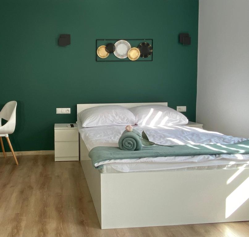 a bed in a bedroom with a green wall at Apartamenty Avia - Energylandia Zator in Spytkowice