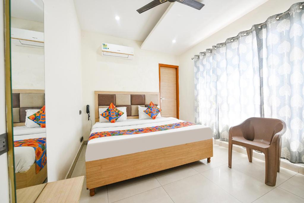 a bedroom with a bed and a chair in it at FabEscape Panchkula Motels in Panchkula