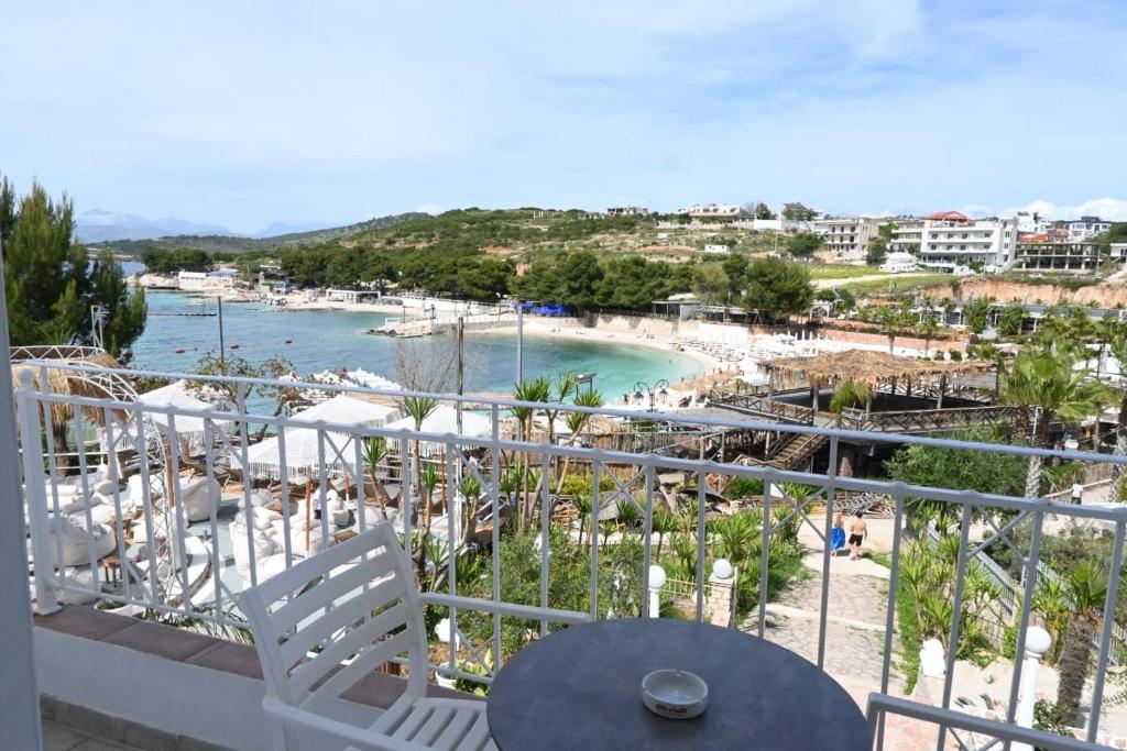 a balcony with a table and chairs and a beach at EMAAR Hotel Ksamil - BEACHFRONT , Newly Renovated in Ksamil