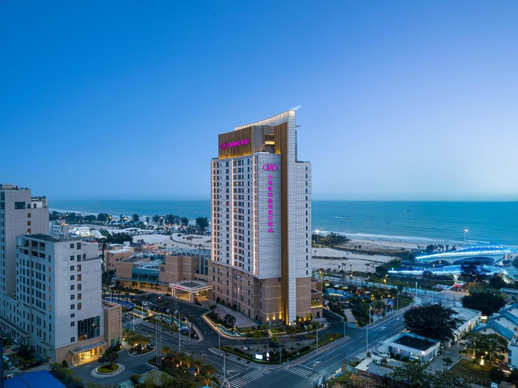 a tall building in a city next to the ocean at Crowne Plaza Beihai Silver Beach, an IHG Hotel in Beihai