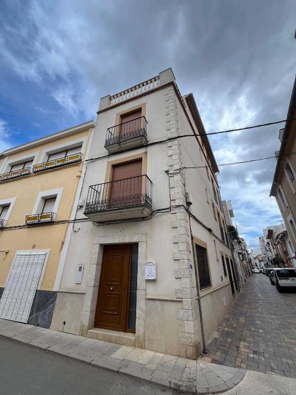 a tall building with two balconies on a street at Casa Rural Angeles in Catí