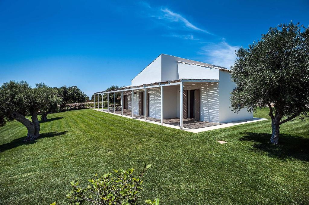 Casa blanca con un gran patio con árboles en Isla Verde, en Scicli