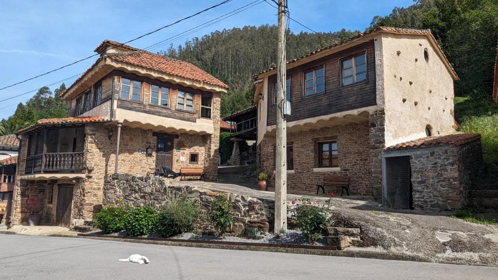 une ancienne maison en pierre sur le côté d'une rue dans l'établissement Las Casas de Isu, à Villaviciosa