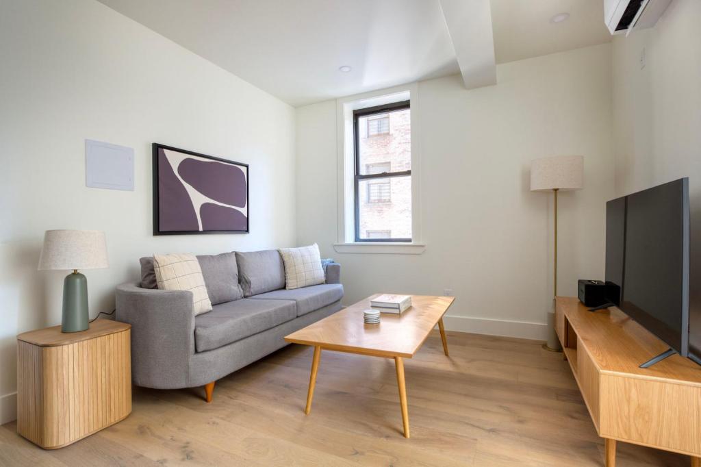 uma sala de estar com um sofá e uma televisão em Blueground East Village elev wd near park NYC-1462 em Nova York