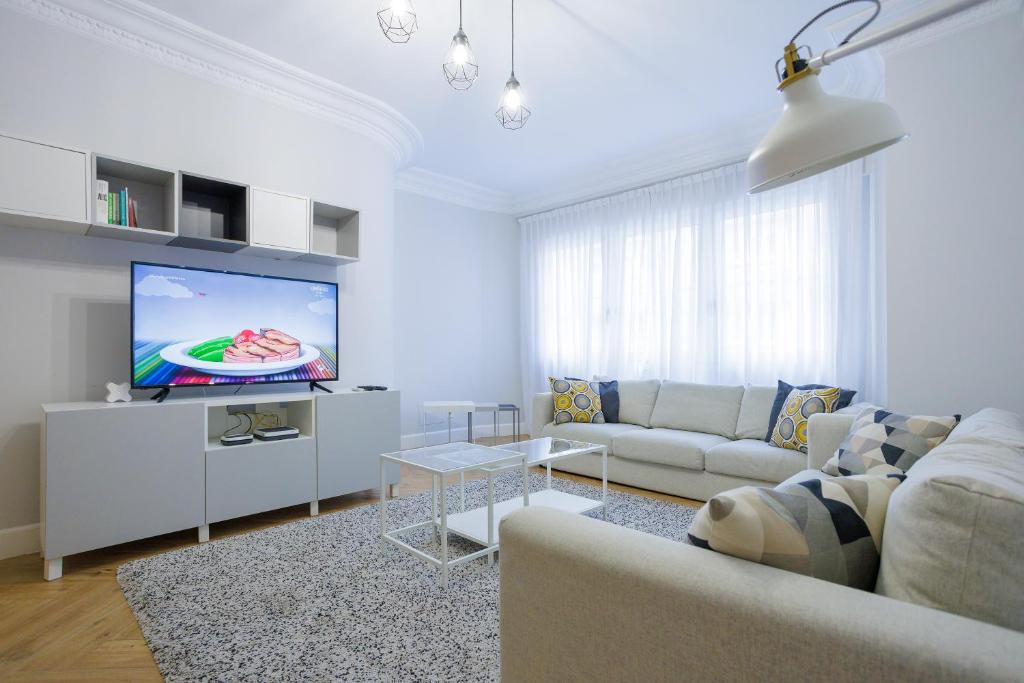 een woonkamer met een bank en een flatscreen-tv bij VT Anboto by Bilbaohost in Bilbao