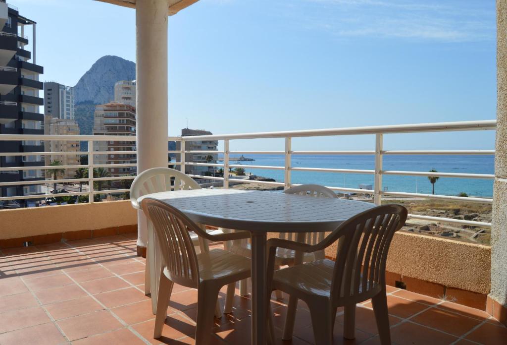 a table and chairs on a balcony with a view of the ocean at Talima in Calpe
