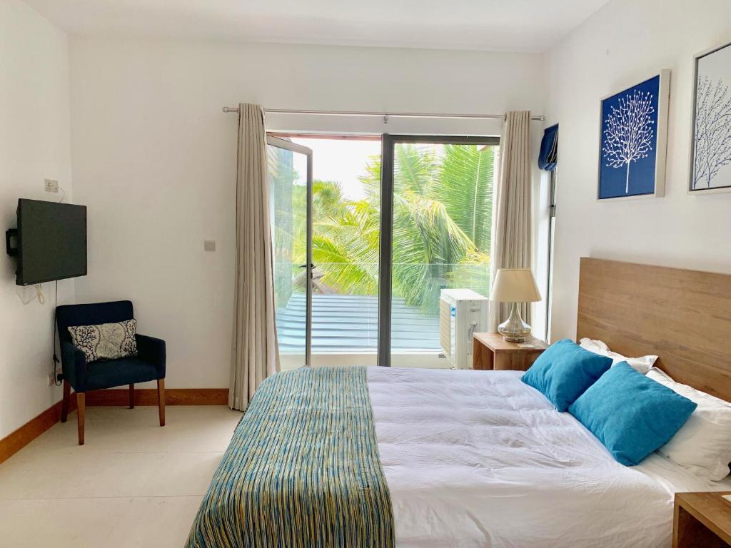 a bedroom with a bed and a sliding glass door at Luxury Apartment on the Beach in Belle Mare