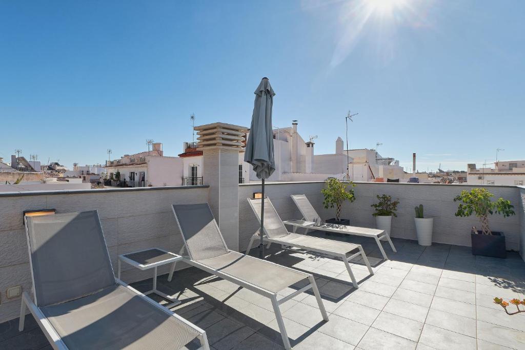 a patio with chairs and an umbrella on a roof at Solaga - Nueva 22 in Nerja