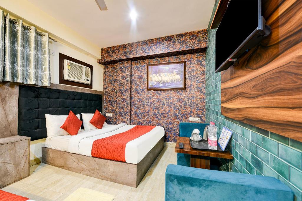 um quarto de hotel com uma cama e uma televisão de ecrã plano em Airport Hotel Ark View em Nova Deli