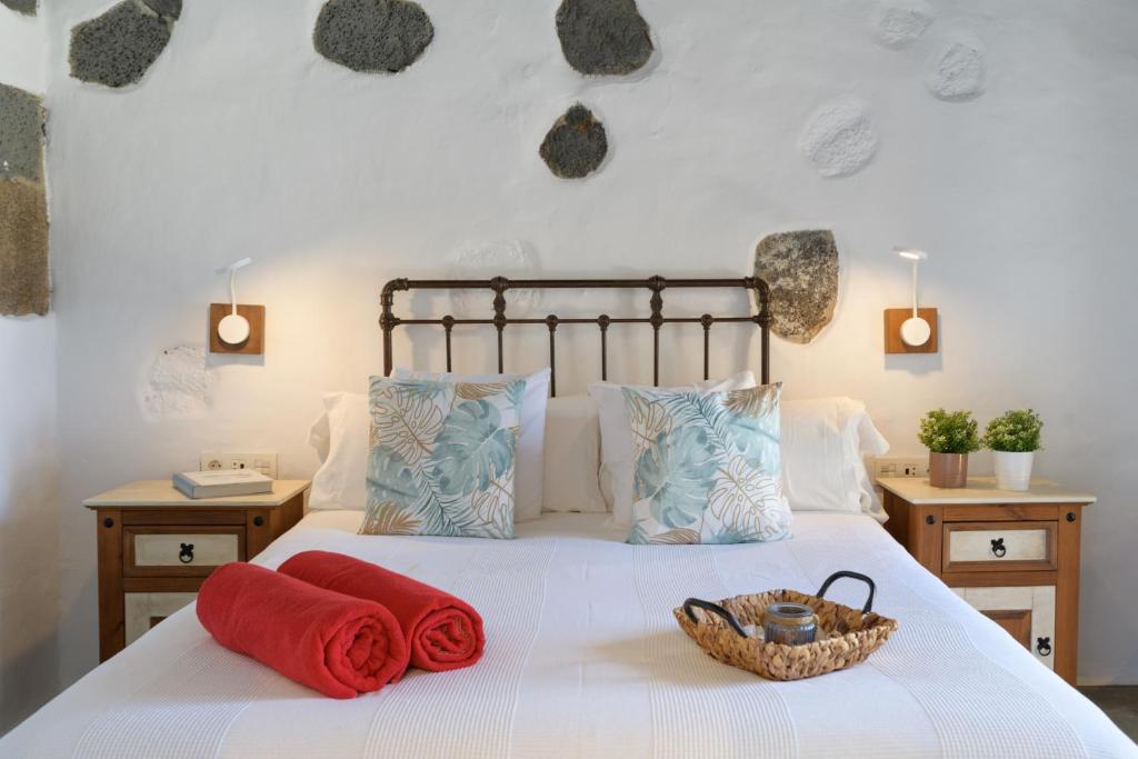 Mácher的住宿－La Casa del Medianero，一张带两个红色毛巾的床和一个篮子
