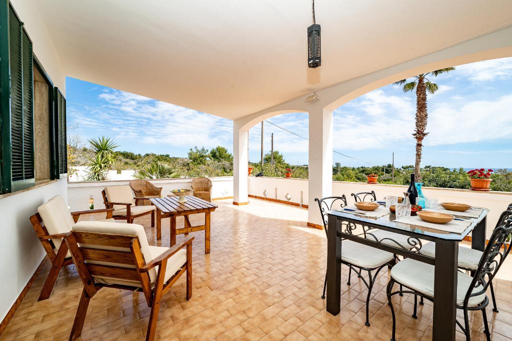 a dining room with a table and chairs on a patio at Villa Anna By Vivimy in Salve