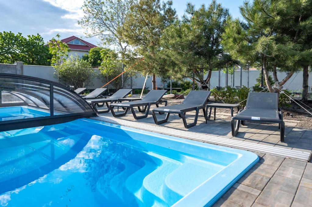 une piscine avec des chaises longues et une piscine dans l'établissement Номер в гостьовому домі "Дача на Фонтанці", à Fontanka