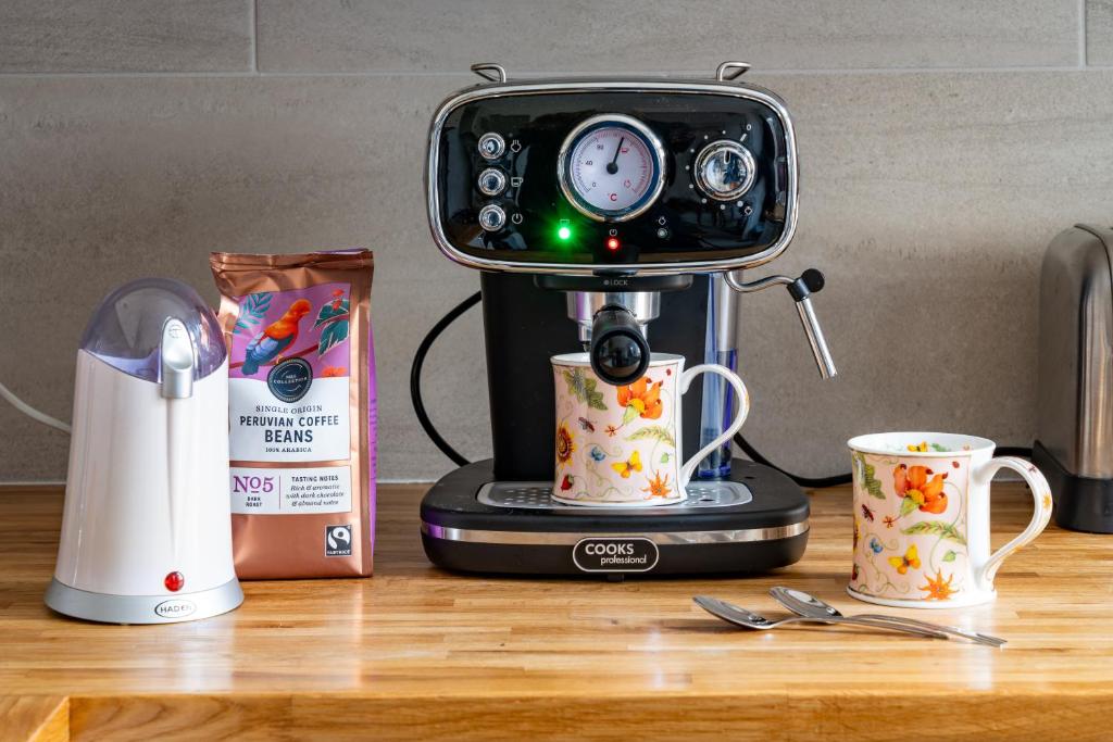 a coffee maker sitting on a counter with two cups at CRAVEN VUE - SKIPTON in Skipton