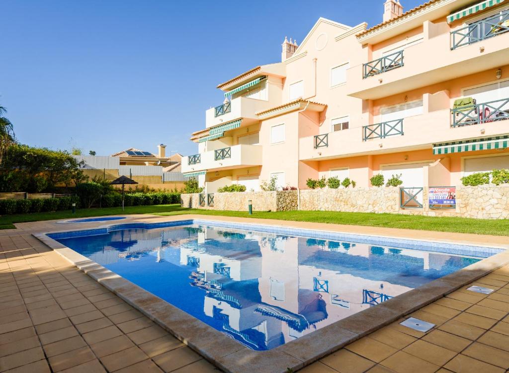 a swimming pool in front of a building at Quinta do Paiva - Jardins do Vale in Albufeira