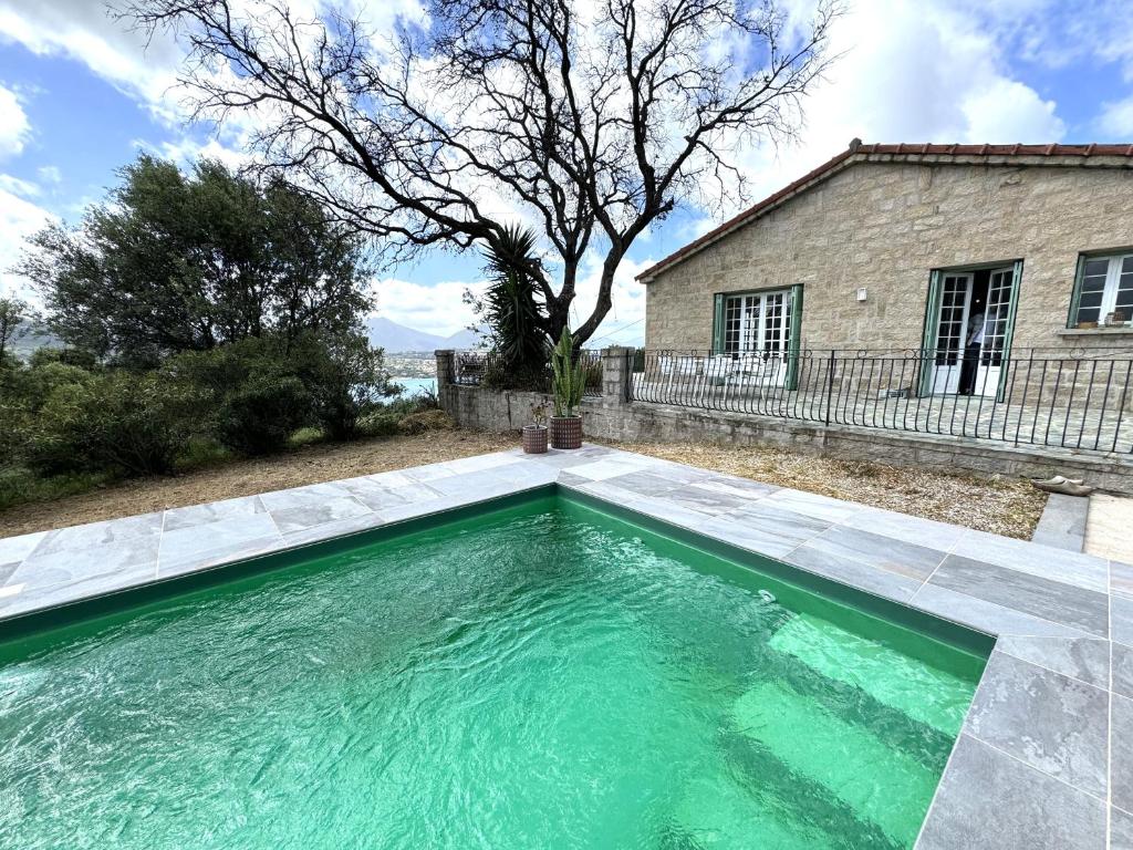 a swimming pool in front of a house at VILLA A MUREDDA, piscine chauffée et vue mer in Olmeto