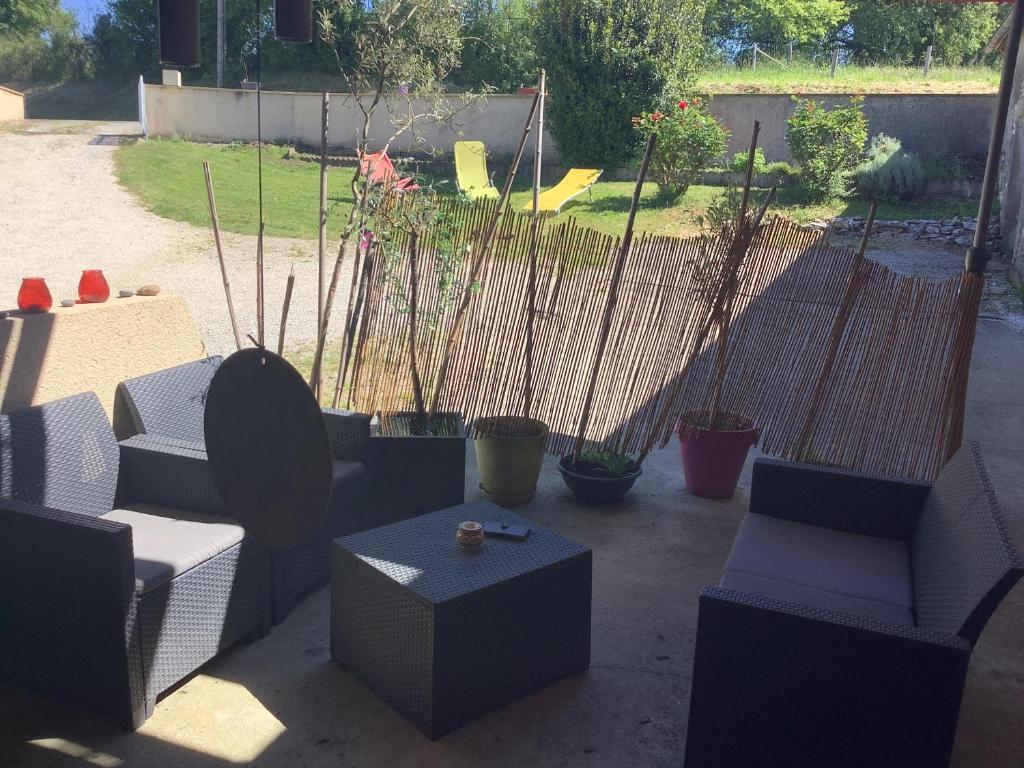 un patio con sofás, una mesa y macetas en Sylvie et Olivier, en Saint-Sozy