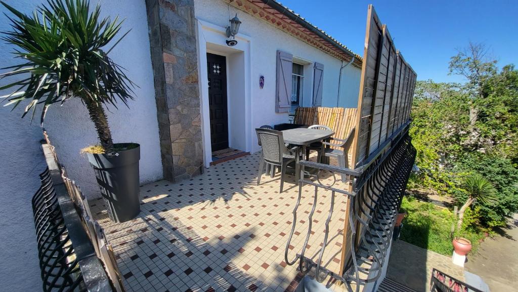 a balcony of a house with a table and a palm tree at Bel Appartement in Vinassan