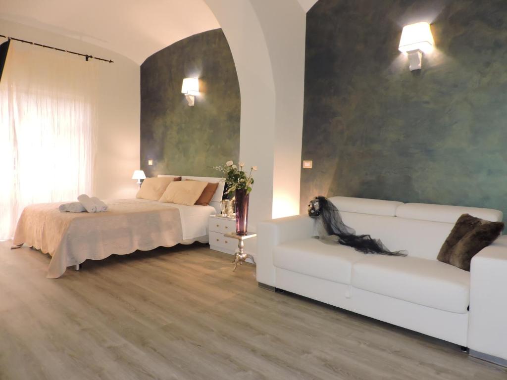 sala de estar con 2 camas y sofá blanco en Anfiteatro Suite, en Roma