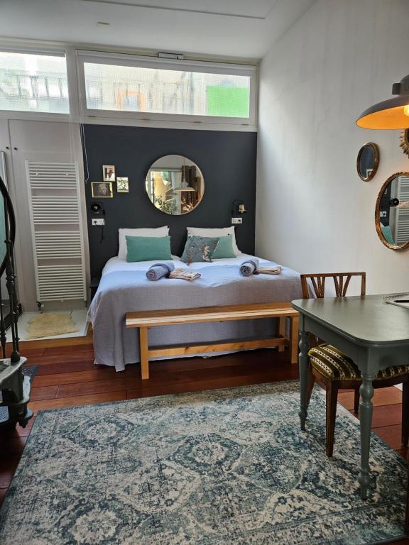 a bedroom with a bed and a table and a mirror at Waterfront Studio in Amsterdam