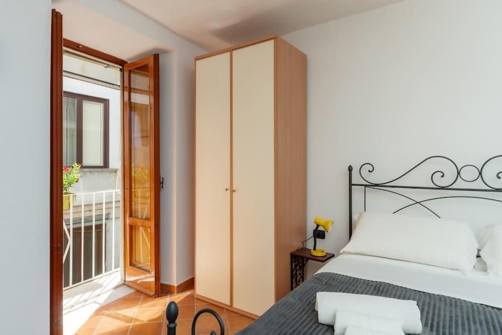 ソレントにあるSorrento Realty Holidays Casa Lenùの大きなベッドとバルコニーのある寝室