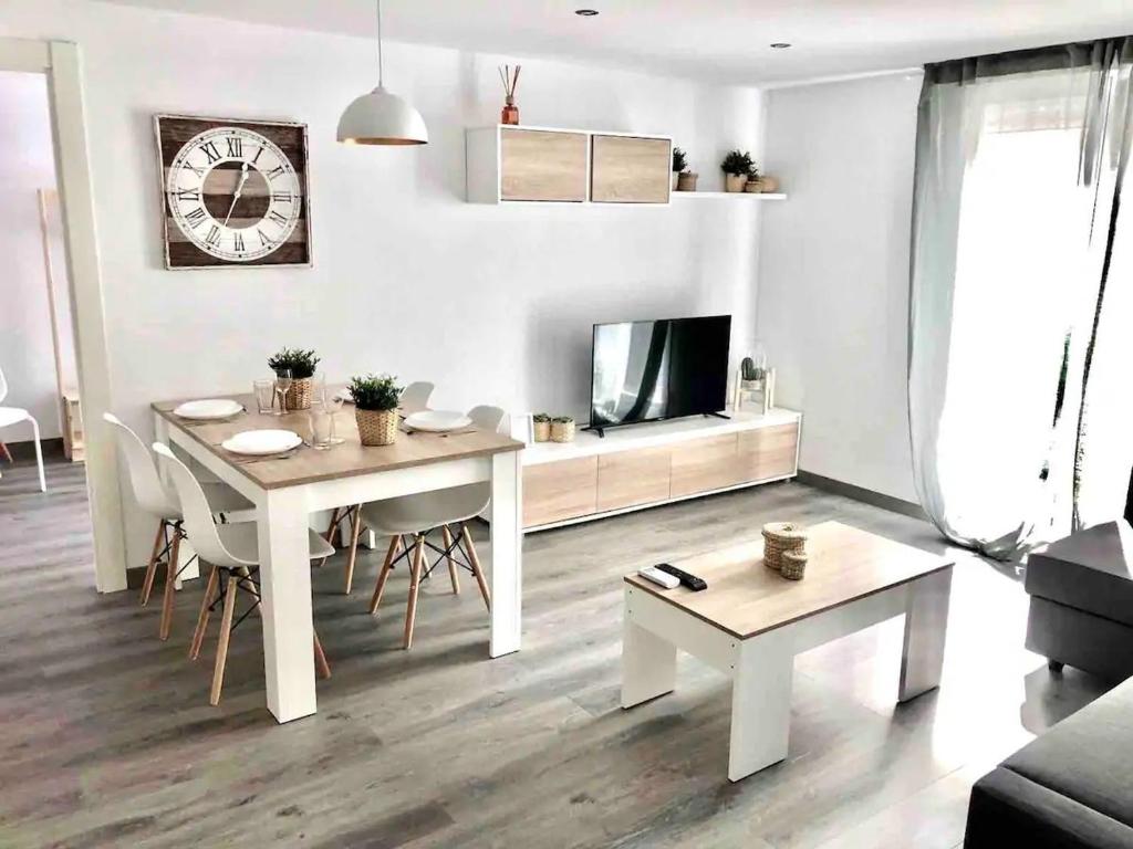 a white living room with a table and a tv at Apartamento Ramon Pignatelli in Zaragoza