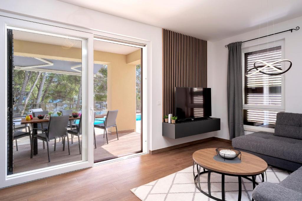 een woonkamer met een bank en een tafel bij Seafront Apartment Totally Beachin with Private Pool in Ivan Dolac