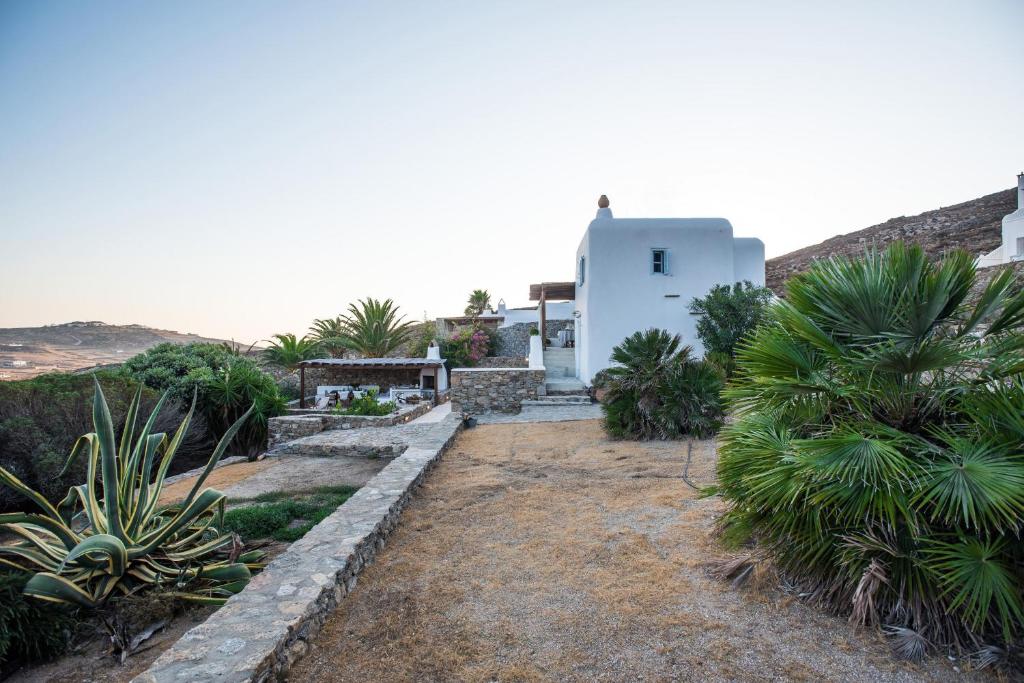 una casa blanca con palmeras y arbustos en Traditional Cycladic House 2 in Mykonos, en Panormos  Mykonos